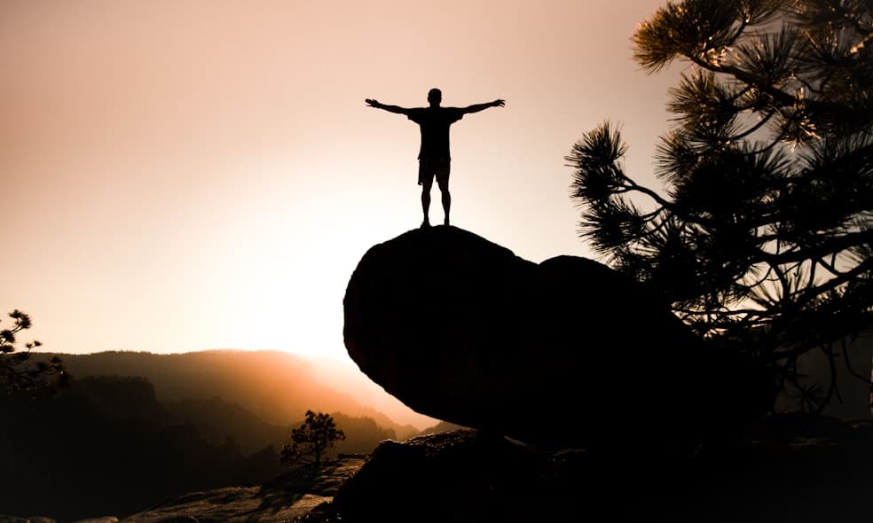 silhouette of person on rock